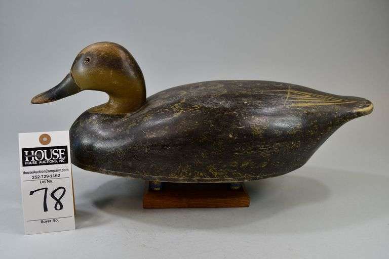 Black Duck, Carver: Wildfowlers Decoys, Babylon, NY.  Decoy has a keel with lead attached and an anchorline attachment. The initials: "JHB" are burned in the bottom. There is also an old white "Olivers" auction tag on the bottom image