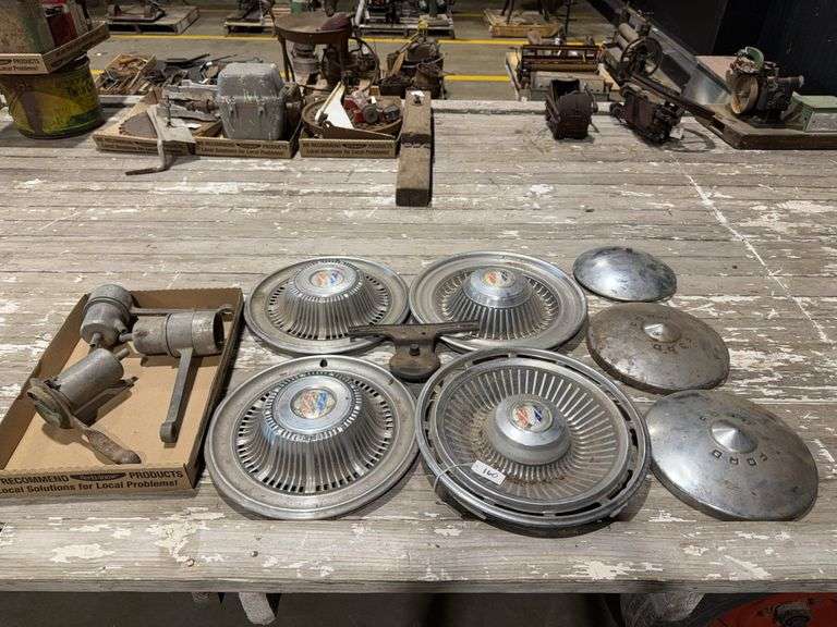 Buick, Ford hubcaps, vintage license plate bracket, and some type of vessels? image