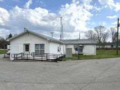 TRACT #1 (12010 Main St SW, Mauckport, IN): 0.325 ac corner lot with 1326 SF former postal building.