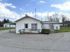 TRACT #1 (12010 Main St SW, Mauckport, IN): 0.325 ac corner lot with 1326 SF former postal building.