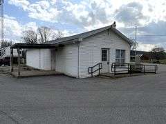 TRACT #1 (12010 Main St SW, Mauckport, IN): 0.325 ac corner lot with 1326 SF former postal building.