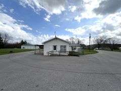 TRACT #1 (12010 Main St SW, Mauckport, IN): 0.325 ac corner lot with 1326 SF former postal building.