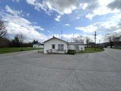 TRACT #1 (12010 Main St SW, Mauckport, IN): 0.325 ac corner lot with 1326 SF former postal building.