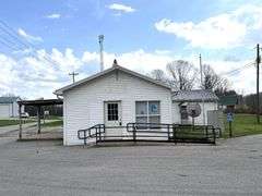 TRACT #1 (12010 Main St SW, Mauckport, IN): 0.325 ac corner lot with 1326 SF former postal building.