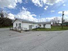 TRACT #1 (12010 Main St SW, Mauckport, IN): 0.325 ac corner lot with 1326 SF former postal building.