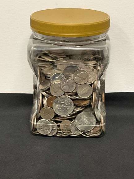 Plastic jar 3/4 full of coins image