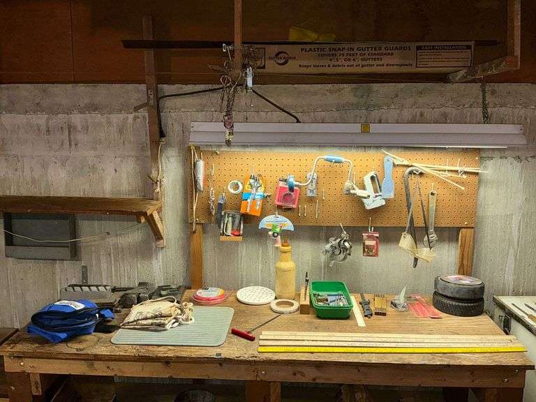 Contents of pegboard and top of work bench, apron, hatchet, wedges image