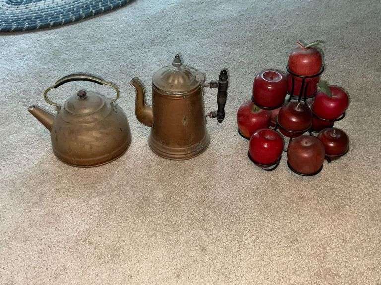 Brass tea and coffee pots.  Wooden apples on metal rack. image