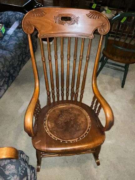 Antique wooden rocking chair with leather seat insert. image