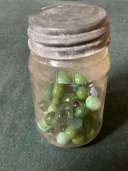 Jar with green and other marbles image