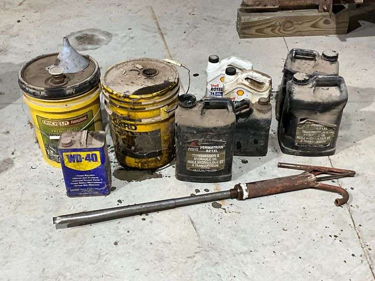 Assortment of motor oils & transmission/hydraulic fluid, all partial jugs, barrel pump image