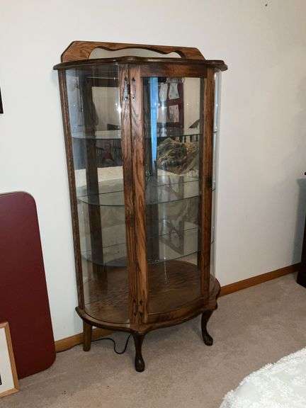 Lighted curved front curio cabinet with glass shelves and mirrored back