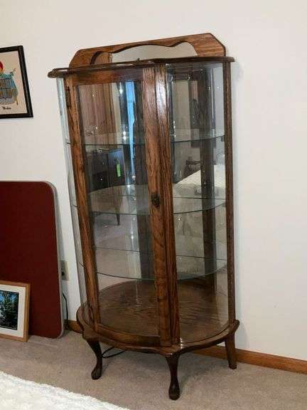 Lighted curved front curio cabinet with glass shelves and mirrored back