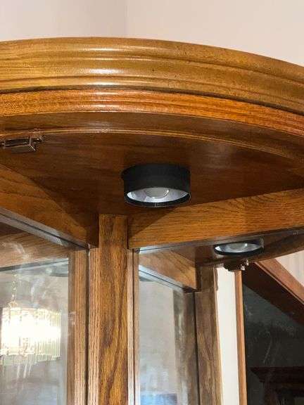 Lighted corner curio cabinet with glass shelves, paw feet, mirrored back