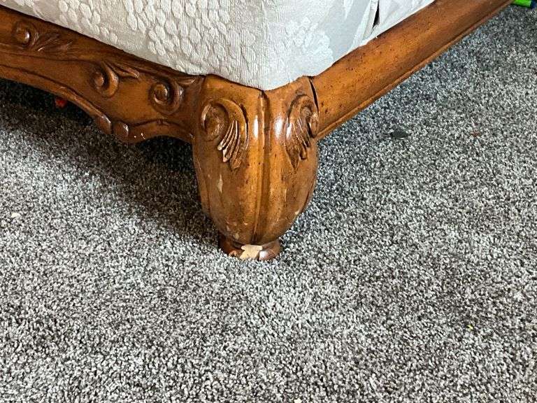 Upholstered loveseat with ornate feet, damage to one foot with throw pillows
