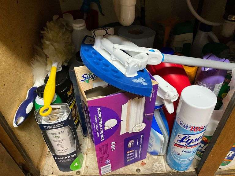 Assortment of cleaning supplies under the sink