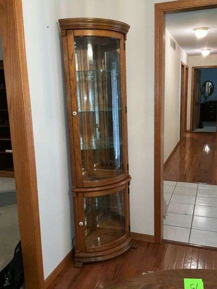 Lighted corner curio cabinet with glass shelves, paw feet, mirrored back