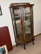 Lighted curved front curio cabinet with glass shelves and mirrored back