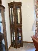 Lighted curio cabinet with glass shelves and mirrored back