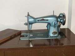 Universal DeLuxe sewing machine in cabinet Model G.B. with accessories
