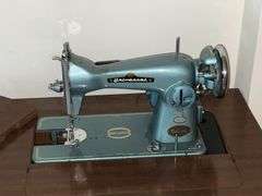 Universal DeLuxe sewing machine in cabinet Model G.B. with accessories