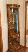 Lighted corner curio cabinet with glass shelves, paw feet, mirrored back