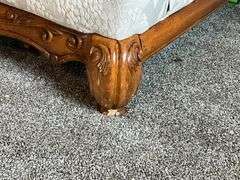 Upholstered loveseat with ornate feet, damage to one foot with throw pillows