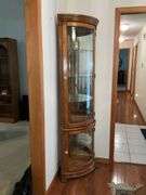Lighted corner curio cabinet with glass shelves, paw feet, mirrored back