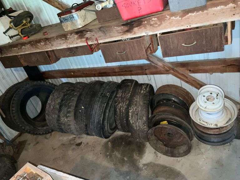 Studded snow tires, trailer tires, and assorted rims. image