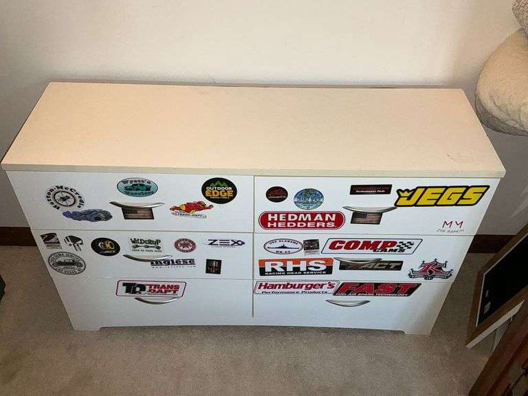 Six-drawer pressed wood dresser with automotive stickers image