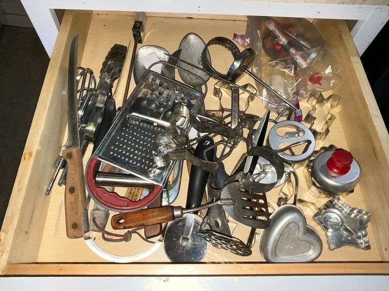 Utensil drawer, cookie cutters, knives, skewers, graters image