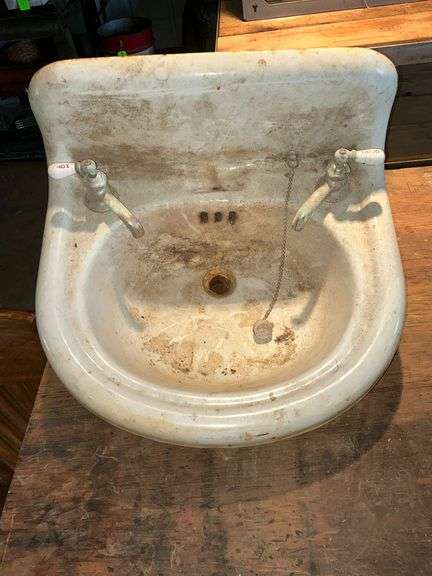 Porcelain sink with intact knobs. image