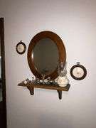 Oval mirror with small shelf and decorations