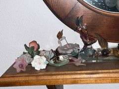 Oval mirror with small shelf and decorations