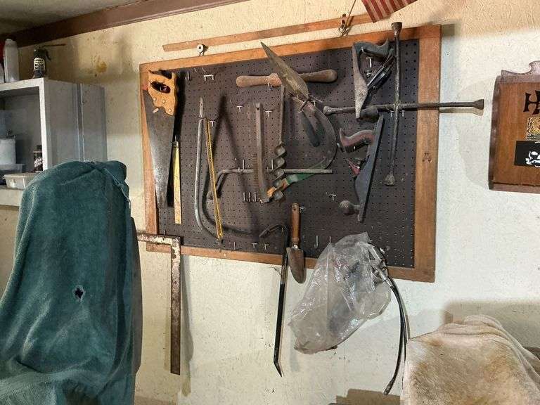 Peg board of tools, planes, pry bar, bow saw, lug wrench, etc. image