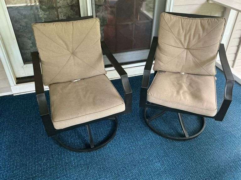 Pair of swivel patio chairs with cushions. image
