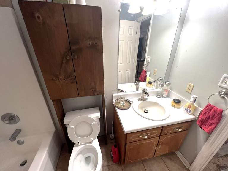 Bath… Bathroom lot marked 1542, includes all content of hallway bath to include assorted towels, home decor, wooden over the toilet storage shelf with content, and more. See pictures for details. image