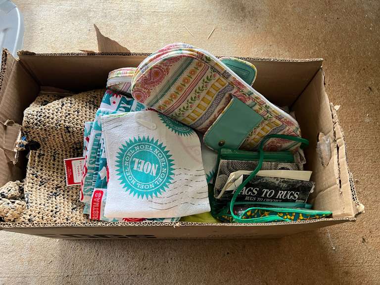 Mystery box of assorted items to include material, woven ladies handbag, seasonal dish towels, knitting needles with storage cases, and much more. See pictures for details. image