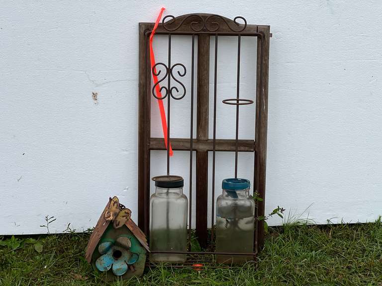 Vintage repurposed trellis in birdhouse with two glass jars image