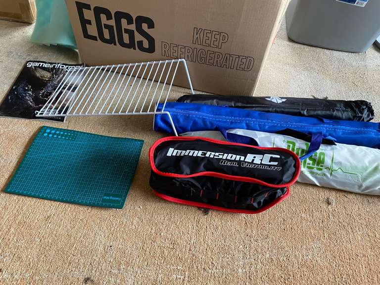 Large mystery box of assorted items to include a small Targus tripod, shelf organizer, assorted flags, maybe drone related, please inspect, see pictures for details. image