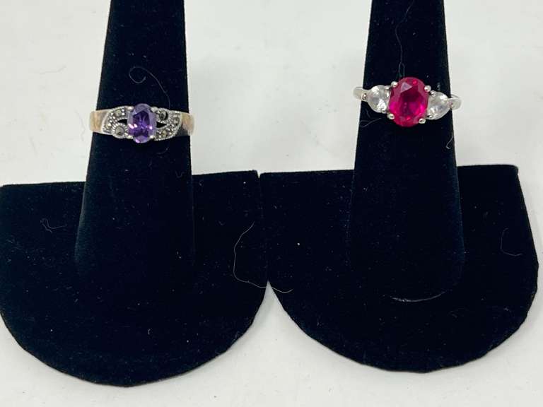 Ladies silver rings, both pieces are stamped 925, includes one with a ruby colored stone flanked by two heart shaped clear stones, also includes one believed to be amethyst with marcasite accents, see pictures for details. image