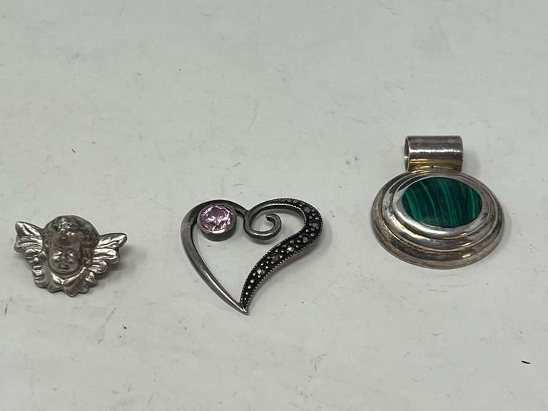 Ladies silver pendants, both pieces are stamped 925, includes an open heart pendant with a pink stone that resembles pink sapphire, also includes an oval pendant with a stone that is believed to be malachite, and a small silver angel pin, stamped 800, this piece contains 80% silver, see pictures for details. ￼ image