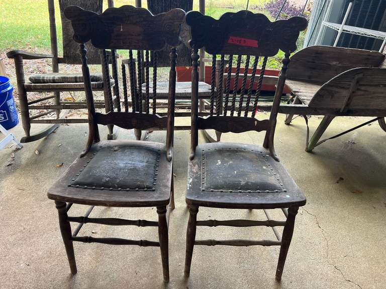 Antique spindle back chair with a carved back and a studded leather seat, set of two, these chairs are well worn, and need some TLC. See pictures for details. image