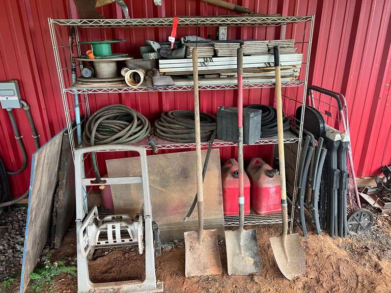 Metal rack with content to include shovels, hose reel, hoses, plastic sawhorses, small tile and more image