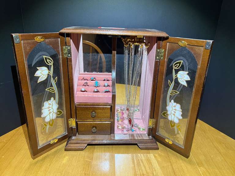 Tall wooden jewelry box, has glass front doors and a floral motif, contains assorted ladies fashion jewelry necklaces, bracelets, and rings. See pictures for details. 