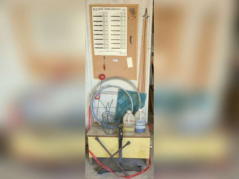 HANDMADE TRUNK AND ITEMS SURROUNDING IN IN AREA MARKED OFF AS 1004 INCLUDING BULLETIN BOARD, PEERLESS PUMP PROMOTIONAL YARDSTICKS, WIRE FRAME HANGING PLANTER BASKETS, FOUR-WAY TIRE TOOLS, DRUM / BARREL STRAP, AND MORE image