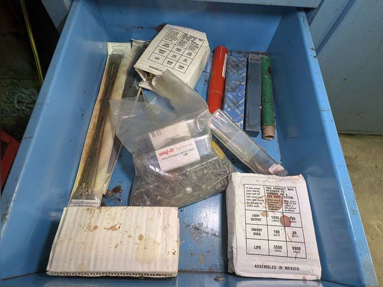 CONTENTS OF CABINET DRAWER MARKED 1043 INCLUDING LIGHT BULBS, FASTENERS, VERY LARGE DRILL BITS, UNUSED RECIPROCATING SAW BLADES, AND MORE image