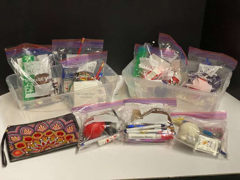 Assortment of giveaway packages, items include hand sanitizer, toothbrush holders, pencils, pens, fidget balls, and more. Tubs are not included, see pictures for details. image