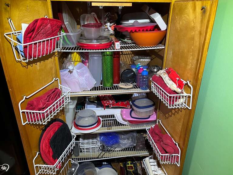 KIT… Pantry lot marked 1080, includes all content of pantry cabinets. Some items include a coffee mug tree, shelf organizer, large assortment of storage containers, paper plates, and more. See pictures for details. image