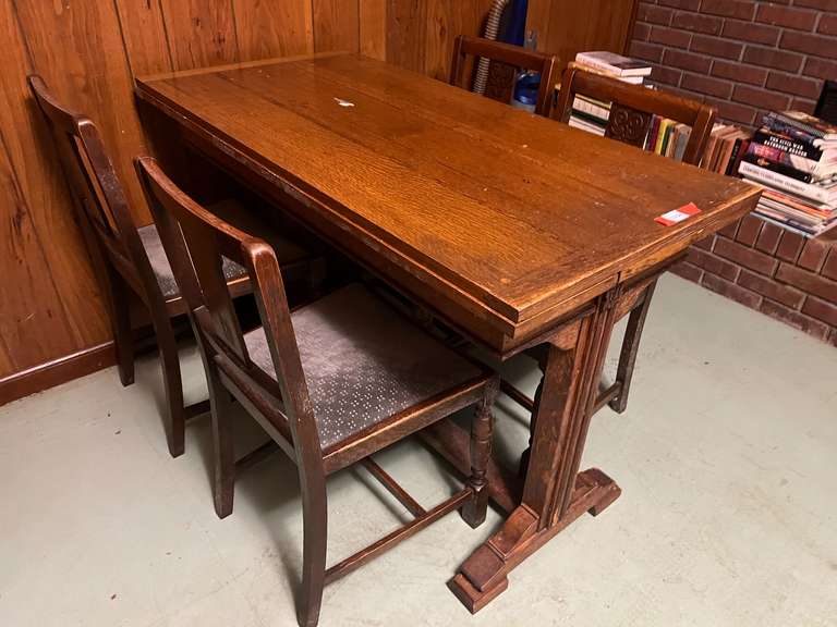 DEN… Antique slide leaf table, believed to be oak, the leaves on this unique piece slide forward under the table surface. Comes with four chairs, see pictures for details.